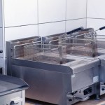 Equipment for deep-frying dishes. Industrial fryers in a restaurant. Stainless steel deep fryers close up.