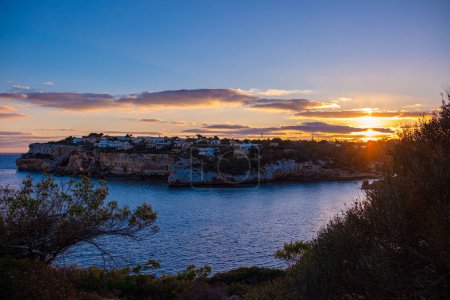 Schöne Aussicht auf Santanyi, Mallorca, Spanien in der goldenen Stunde des Sonnenuntergangs. Eine Stadt in den Strahlen der untergehenden Sonne, des schönen Himmels und der ruhigen See. Natürlicher Schuss.