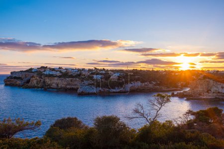 Belle vue panoramique sur Santanyi, Majorque, Espagne à l'heure dorée du coucher du soleil. Une ville dans les rayons du soleil couchant, beau ciel et mer calme. Plan naturel.