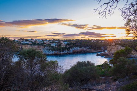Belle vue panoramique sur Santanyi, Majorque, Espagne à l'heure dorée du coucher du soleil. Une ville dans les rayons du soleil couchant, beau ciel et mer calme. Plan naturel.