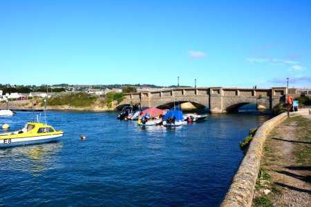 Foto de AXMOUTH, Reino Unido - 30 de agosto de 2022 - Puente sobre el hacha del río con pequeños barcos de pesca en primer plano, Axmouth, Devon, Reino Unido, Europa, 30 de agosto de 2022. - Imagen libre de derechos