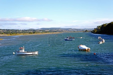Foto de AXMOUTH, Reino Unido - 30 de agosto de 2022 - Pequeños barcos pesqueros amarrados a lo largo del río Axe con la campiña de Devon en la parte trasera, Axmouth, Devon, Reino Unido, Europa, 30 de agosto de 2022. - Imagen libre de derechos
