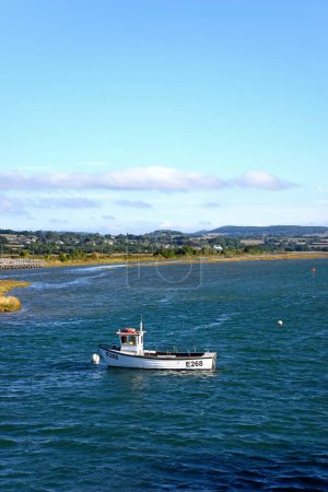 Foto de AXMOUTH, Reino Unido - 30 de agosto de 2022 - Pequeño barco pesquero amarrado a lo largo del río Axe con el campo de Devon en la parte trasera, Axmouth, Devon, Reino Unido, Europa, 30 de agosto de 2022. - Imagen libre de derechos