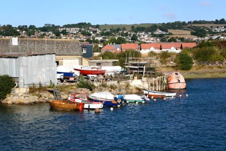 Foto de AXMOUTH, Reino Unido - 30 de agosto de 2022 - Boatyard along the River Axe with small fishing boats amored in the foreground, Axmouth, Devon, Reino Unido, Europa, 30 de agosto de 2022. - Imagen libre de derechos
