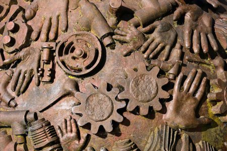 Photo for CHARD, UK - JUNE 22, 2023 - Hand casts and cogs detail on the boulder statue by Neville Cable along High Street, Chard, Somerset, UK, Europe, June 22, 2023. - Royalty Free Image