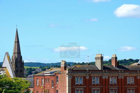 City buildings and church spire rear seen from Rougemont Gardens, Exeter, Devon, UK, Europe