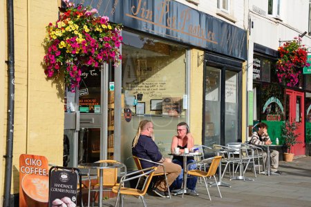 Téléchargez les photos : GLASTONBURY, Royaume-Uni - 05 septembre 2023 - Couple assis devant un café sur la chaussée le long de Magdalene Street, Glastonbury, Somerset, Royaume-Uni, Europe, 05 septembre 2023. - en image libre de droit