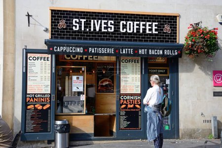 Téléchargez les photos : EXETER, Royaume-Uni - 22 AOÛT 2023 - Vue de face du café St Ives avec une femme au premier plan le long de High Street dans le centre-ville, Exeter, Devon, Royaume-Uni, Europe, 22 août 2023. - en image libre de droit