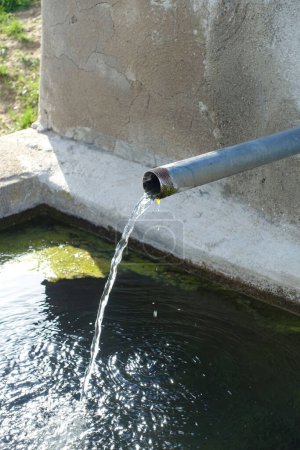 Foto de Primer plano de la fuente de agua potable que fluye de la tubería, el agua clara fluye de la fuente, - Imagen libre de derechos