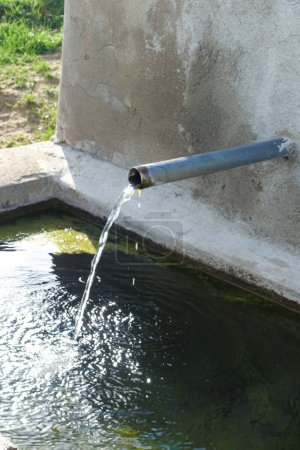 Foto de Primer plano de la fuente de agua potable que fluye de la tubería, el agua clara fluye de la fuente, - Imagen libre de derechos