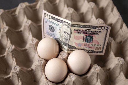 Photo for There are eggs in the egg carton and 100 dollars on it, implying an increase in egg prices, - Royalty Free Image