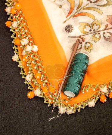 Handgestrickter Schal und Kopftuchmuster, handbesticktes und orangefarbenes Kopftuch in Nahaufnahme.