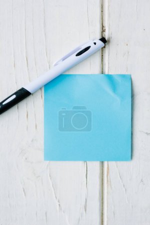 Foto de Pegatina azul y pluma sobre una superficie blanca - Imagen libre de derechos