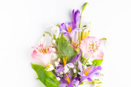 Téléchargez les photos : Bouquet de fleurs de printemps plat posé sur un fond blanc. Vue du dessus et espace de copie - en image libre de droit