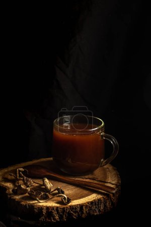 Téléchargez les photos : Thé aux champignons. tasse en verre avec une boisson à base de champignons séchés. premier plan flou, photo basse - en image libre de droit