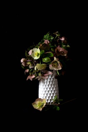 Stillleben. Luxus-Blumensträuße in einer weißen Vase auf schwarzem Hintergrund. Stimmungsvolle Blumen. Farbenpracht.