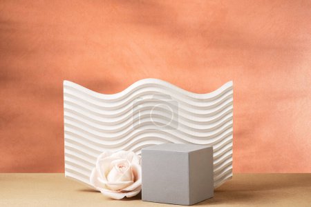 Stillleben. Abstrakte dreidimensionale Kompositionen aus geometrischen Formen und cremefarbener Rose auf dunkelorangefarbenem Hintergrund mit schönen Schatten