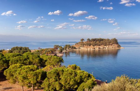 Foto de Trees and Beach on the Coast in a Touristic Town by the Aegean Sea. Kusadasi, Turquía. Cielo nublado Art Render. - Imagen libre de derechos