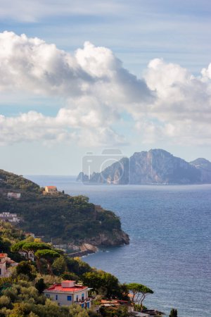 Téléchargez les photos : Maisons résidentielles sur la montagne au bord de la mer avec l'île Capri en arrière-plan. Près de Ville Touristique de Sorrente, Italie. - en image libre de droit