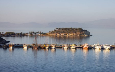 Téléchargez les photos : Bateaux à Marina sur la côte dans une ville touristique au bord de la mer Égée. Kusadasi, Turquie. Matin ensoleillé Lever du soleil. - en image libre de droit