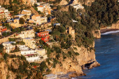 Foto de Touristic Town, Positano, on Rocky Cliffs and Mountain Landscape by the Tyrrhenian Sea. Costa Amalfitana, Italia. Sunny Sunset - Imagen libre de derechos
