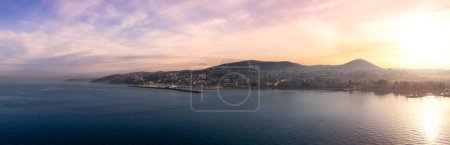 Photo for Homes and Buildings in a Touristic Town by the Aegean Sea. Kusadasi, Turkey. Colorful Sunrise Art Render. Panoramic Aerial View from Cruise Ship - Royalty Free Image