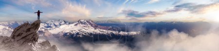 Téléchargez les photos : Adventurous Woman Randonneur debout sur le sommet du pic glacé avec des montagnes rocheuses en arrière-plan. Aventure Composite. Rochers de rendu 3d. Image aérienne du paysage de la Colombie-Britannique, Canada. Coucher de soleil - en image libre de droit