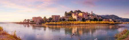 Photo for Old Residential Homes near river and sea in Ventimiglia, Italy. Fall Season. Sunset Sky Art Render. Panorama - Royalty Free Image