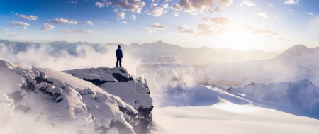Téléchargez les photos : Homme aventureux Randonneur debout sur le sommet du pic glacé avec des montagnes rocheuses en arrière-plan. Aventure Composite. Rochers de rendu 3d. Image aérienne du paysage de la Colombie-Britannique, Canada. Coucher de soleil - en image libre de droit