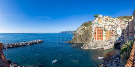 Foto de Boats in marina and colorful apartment homes in touristic town, Riomaggiore, Italy. Cinque Terre National Park. Panorama - Imagen libre de derechos
