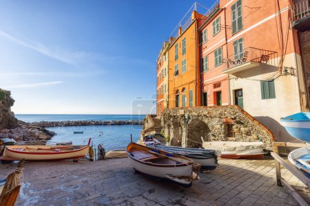 Téléchargez les photos : Boats in marina and colorful apartment homes in touristic town, Riomaggiore, Italy. Cinque Terre National Park - en image libre de droit