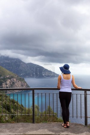 Téléchargez les photos : Woman tourist looking at Mountain Landscape by the Tyrrhenian Sea. Amalfi Coast, Italy. Nature Background. Adventure Travel - en image libre de droit
