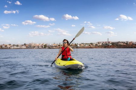 Foto de Adventurous Woman on a Kayak paddling in the Mediterranean Sea. Cape Palos, Spain, Adventure Travel Concept - Imagen libre de derechos