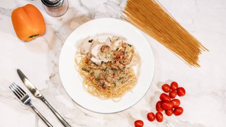 Photo for Dinner plate on the table. Gourmet Pasta with sause and sundried tomatoes. Chicken on the side. - Royalty Free Image