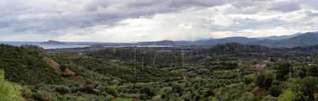 Photo for Panoramic View of Farm Fields and Town on the Sea Coast. Santa Maria Navarrese, Sardinia, Italy. Cloudy and Rainy Sky. - Royalty Free Image