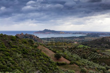 Photo for View of Farm Fields and Town on the Sea Coast. Santa Maria Navarrese, Sardinia, Italy. Cloudy and Rainy Sky. - Royalty Free Image