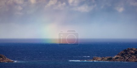 Téléchargez les photos : Rocky Coast and Sea with colorful Rainbow in Sky. Sardinia, Italy. Nature Background. - en image libre de droit