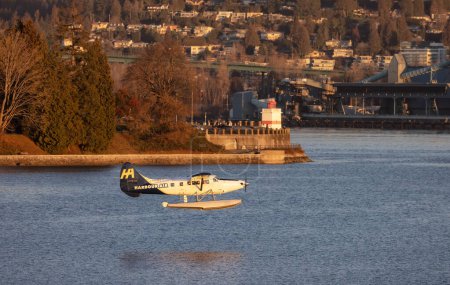 Téléchargez les photos : Vancouver, British Columbia, Canada - January 29, 2023: Harbour Air Float Airplane taking off from Vancouver Harbour Airport during winter Sunrise. - en image libre de droit