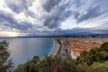 Téléchargez les photos : Plage de sable par la ville historique de Nice, France. Vue de Castle Hill. Soirée nuageuse avant le coucher du soleil. Angle large - en image libre de droit