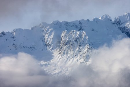 Téléchargez les photos : Tantalus Range covered in Snow and Clouds during Winter Season. Near Whistler and Squamish, British Columbia, Canada. Nature Background - en image libre de droit