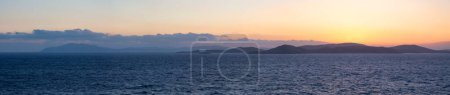 Téléchargez les photos : Rocky Island on Mediterranean Sea. Rinia near Mikonos, Greece, Europe. Nature Background Panorama. Sunrise Sky - en image libre de droit
