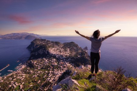 Photo for Adventure Woman Hiking on mountain at Touristic Town, Capri Island, in Bay of Naples, Italy. Twilight Sunrise Sky Art Render. - Royalty Free Image