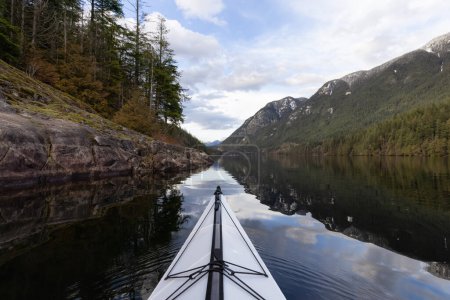 Foto de Kayak en aguas tranquilas con fondo de paisaje montañoso canadiense. Buntzen Lake en Vancouver, Columbia Británica, Canadá. - Imagen libre de derechos