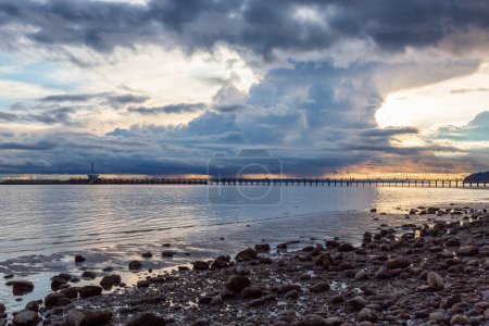 Foto de Rocky Beach y White Rock Pier en la costa oeste del Océano Pacífico. Cielo nublado del atardecer dramático. Vancouver, Columbia Británica, Canadá. - Imagen libre de derechos