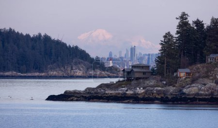 Photo for Cabins on Passage Island with Downtown City, Lighthouse Park and Mnt Baker in Background. Vancouver, British Columbia, Canada. - Royalty Free Image