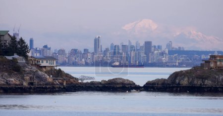 Photo for Cabins on Passage Island with Downtown City Buildings and Mnt Baker in Background. Vancouver, British Columbia, Canada. - Royalty Free Image