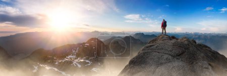Téléchargez les photos : Homme aventureux debout au sommet de Mountain Cliff. Extreme Adventure Composite. 3d Rendering Peak. Image aérienne de fond de la Colombie-Britannique, Canada. - en image libre de droit