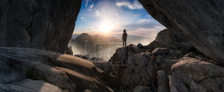 Photo for Adventurous Woman Standing in cave on top of Mountain. Extreme Adventure Composite. 3d Rendering Peak. Background Aerial Image from British Columbia, Canada. - Royalty Free Image
