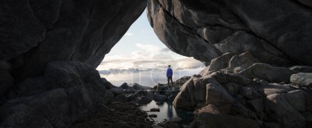 Photo for Adventurous Man Standing in cave on top of Mountain. Extreme Adventure Composite. 3d Rendering Peak. Background Aerial Image from British Columbia, Canada. - Royalty Free Image