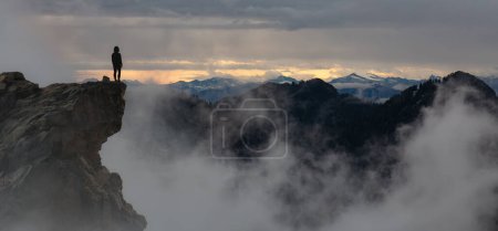 Téléchargez les photos : Femme aventureuse debout au sommet de Mountain Cliff. Extreme Adventure Composite. 3d Rendering Peak. Image aérienne de fond de la Colombie-Britannique, Canada. - en image libre de droit